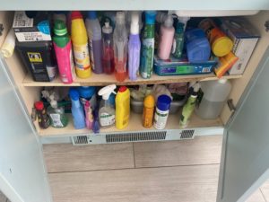 A clutter under the sink cupboard full of cleaning products